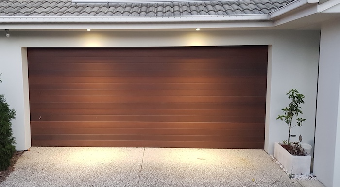 Wooden garage door with outdoor lighting