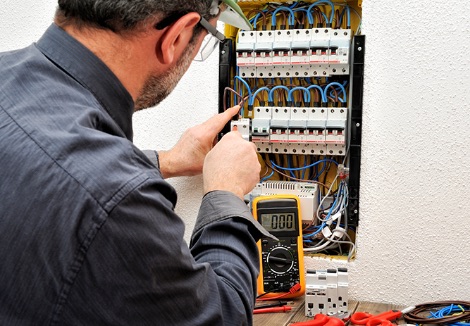 An electrician at work repairing electrical cabling.